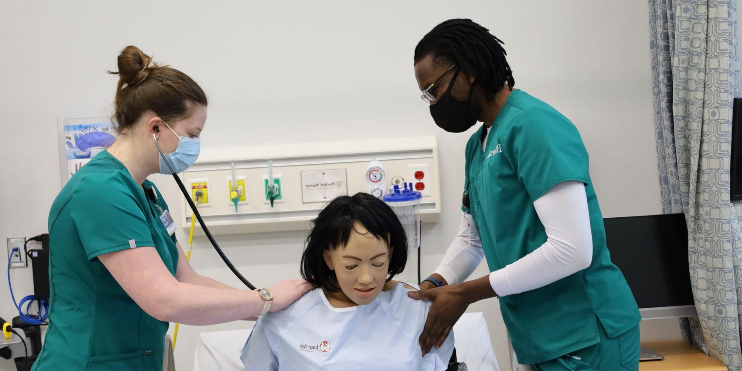 TWO NURSING STUDENTS WITH SIM DOLL